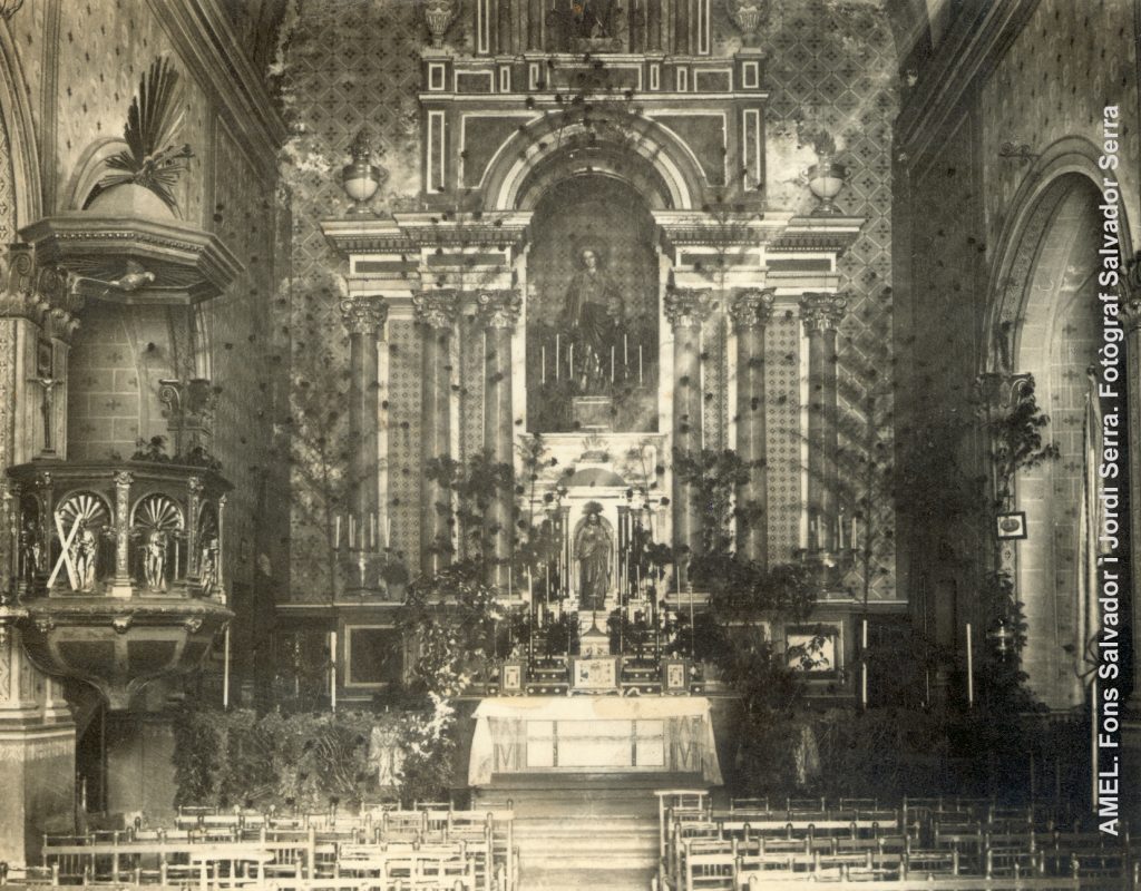 Altar major de la l’església parroquial de Santa Magdalena engalanat amb branques i flors. Abans de 1936.